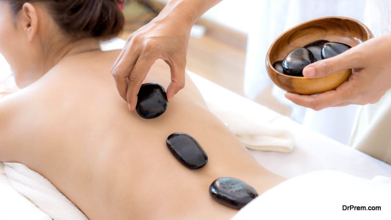 close up beautiful and healthy woman during a back stone therapy massage in spa salon