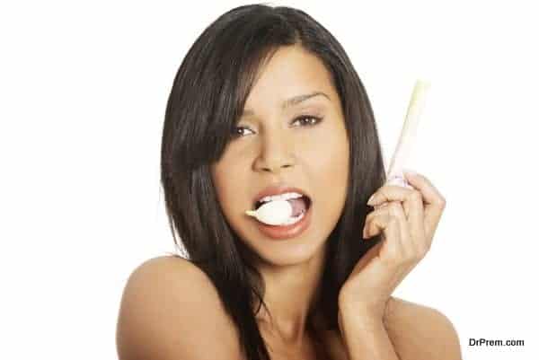 Young beautiful woman eating garlic. Natural antibiotic that fig