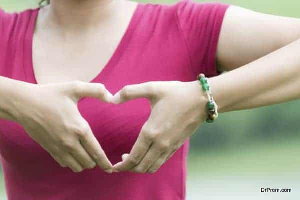 Female hands in the form of heart on nature