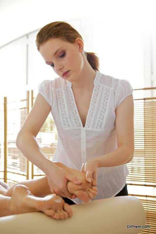 Young woman receiving foot massage from masseuse