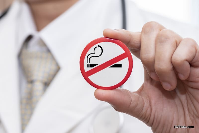 A doctor holding a badge of stop smoking sign