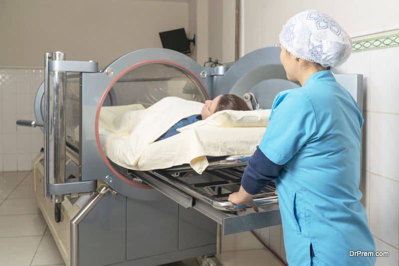 Nurse in uniform introducing a patient to enter the hyperbaric chamber in a clinic.