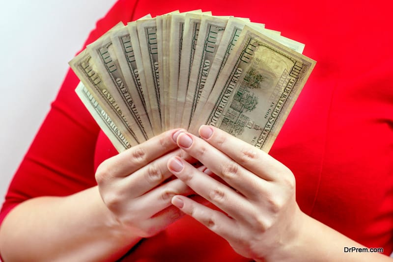 Woman in red dress holding and counting cash money