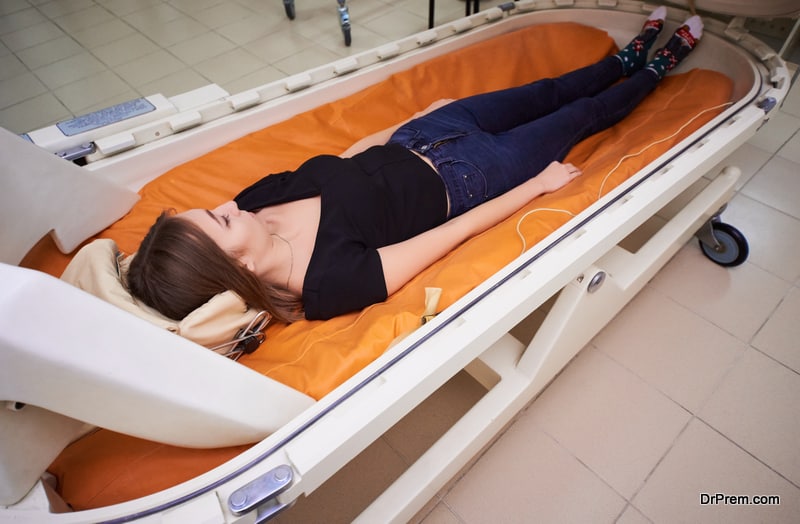 a girl in a black T-shirt lies in a hyperbaric chamber, oxygen therapy, a medical room