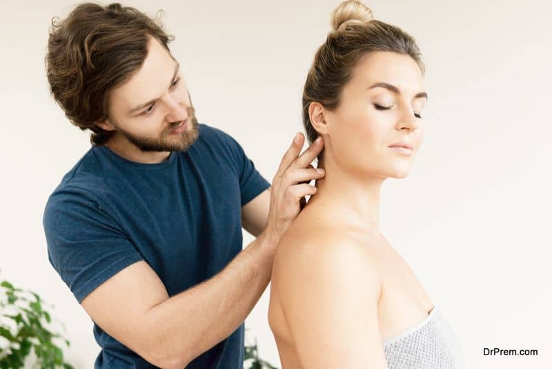Professional masseur using acupressure techniques for client's neck massage