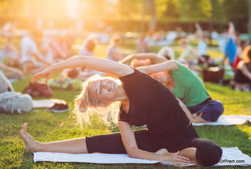 A group of young people do yoga in the Park at sunset