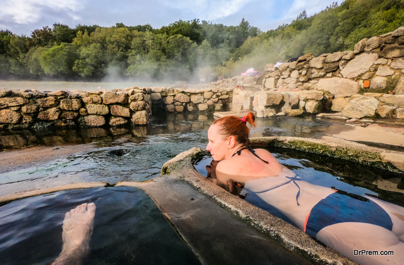 Woman relaxes and enjoys natural hot thermal water roman spa