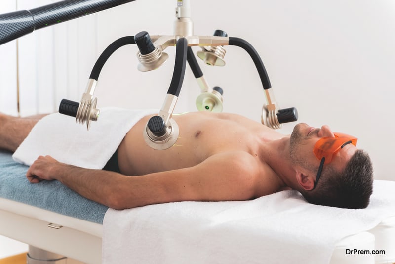 Man having laser treatment for body shaping in aesthetic clinic