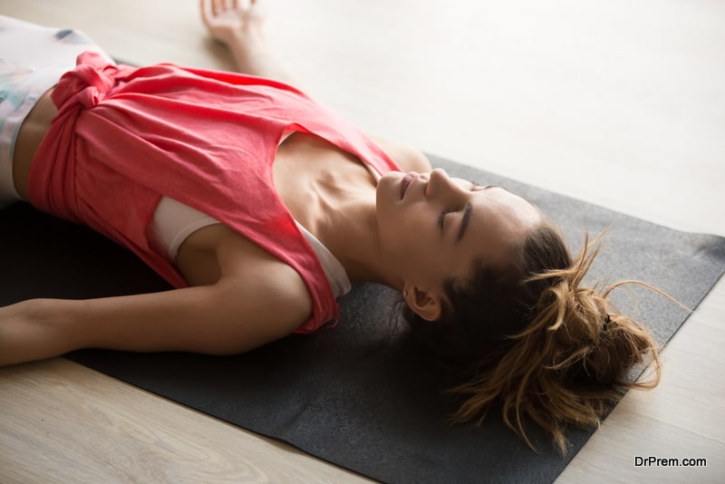 Close up image of young active woman lying on yoga mat