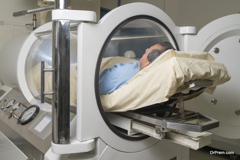 Man inside a cylindrical machine for hyperbaric treatment