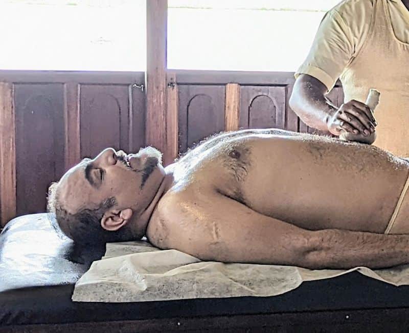 Dr. Prem receiving Ayurvedic massage therapy in Coconut Lagoon