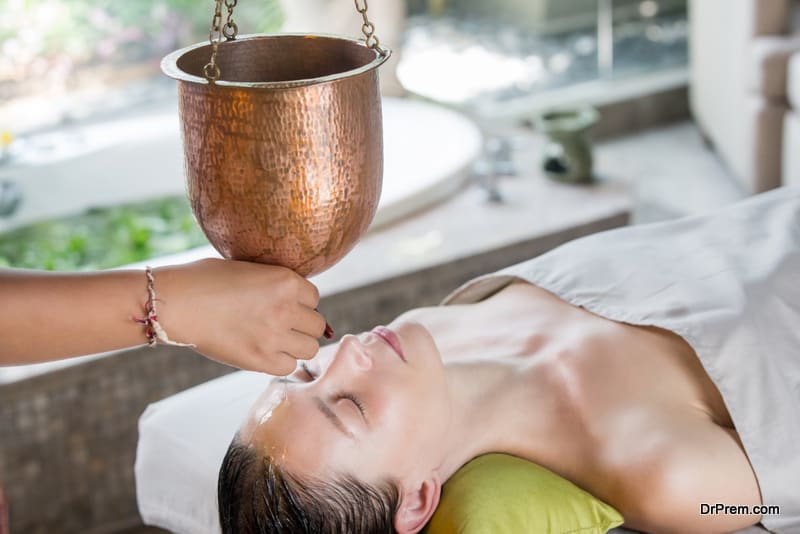 Shirodhara, an Ayurvedic healing technique. Oil dripping on the female forehead