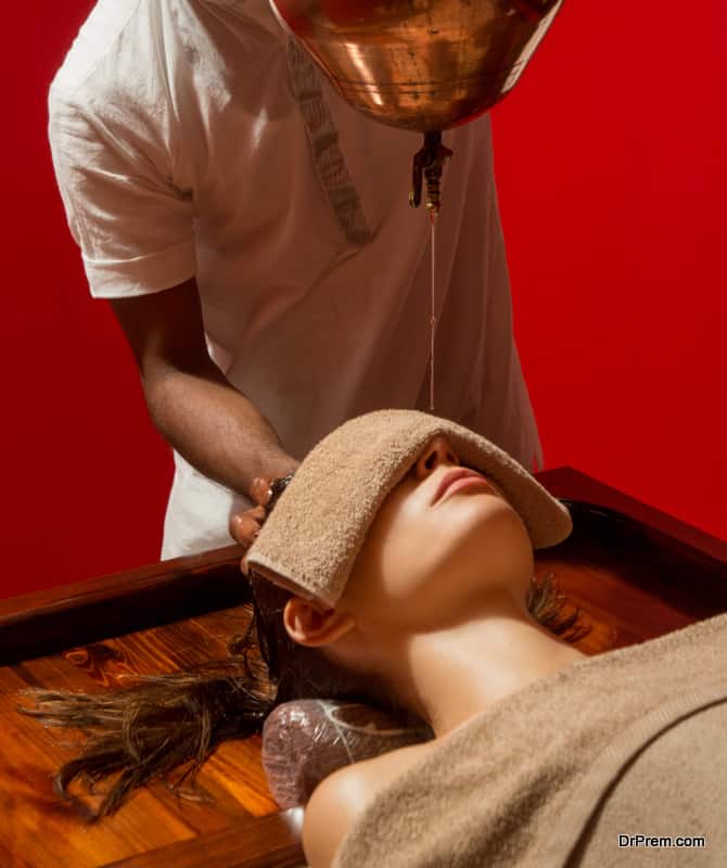 Shirodhara, an Ayurvedic healing technique. Oil dripping on the female forehead. Portrait of a young woman at an ayurvedic massage session with aromatic oil dripping on her forehead and hair.