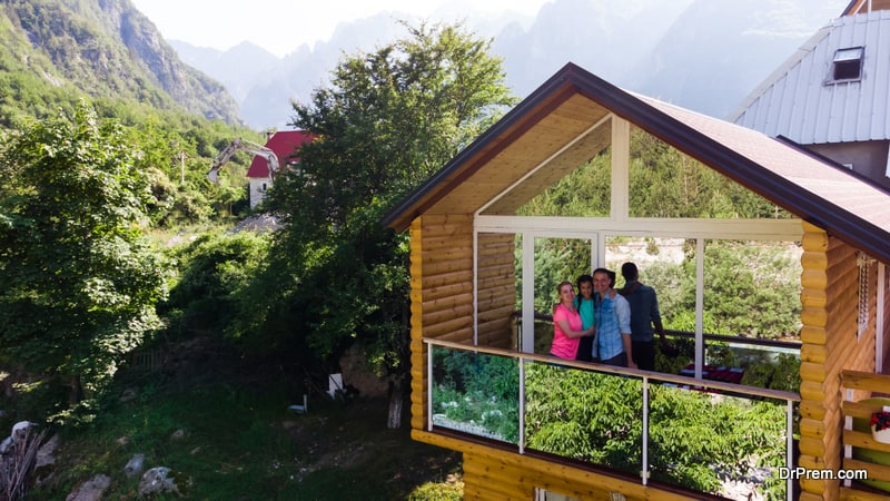 A Guide to Wellness Resort Cottages and Villas – Definition, Features, Planning, Design, Benefits, and More 27 family-on-wooden-cottage-porch-on-mountain-hill-