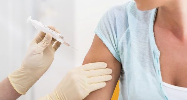 Woman at doctor getting vaccination syringe