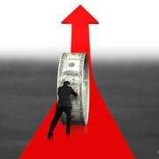 Businessman pushing money circle on growing red arrow