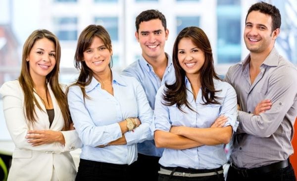 Happy business team with arms crossed at the office