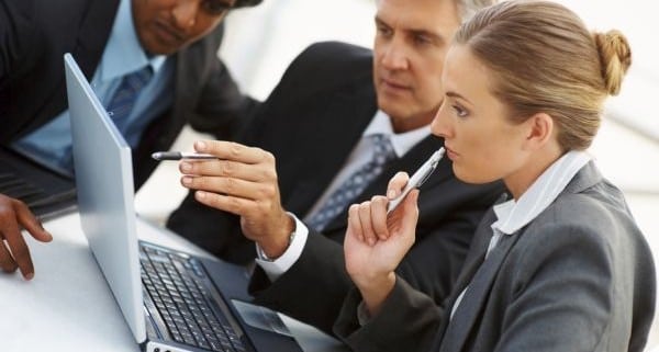 Team of business people working together on a laptop