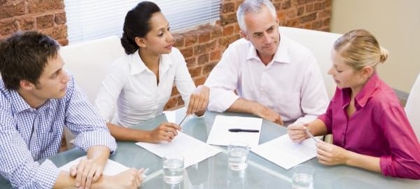 Four businesspeople in boardroom talking