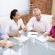 Four businesspeople in boardroom talking