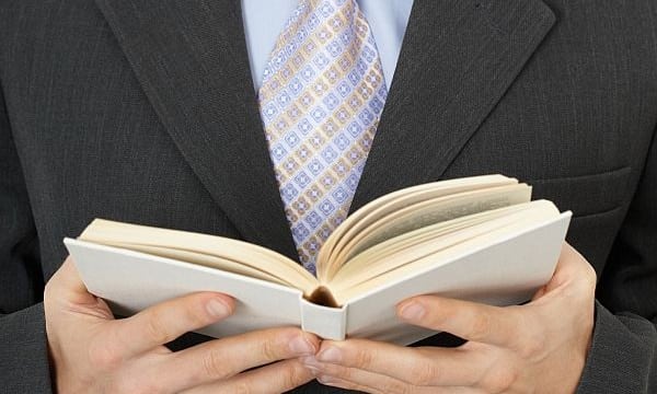 Businessman reading statute book