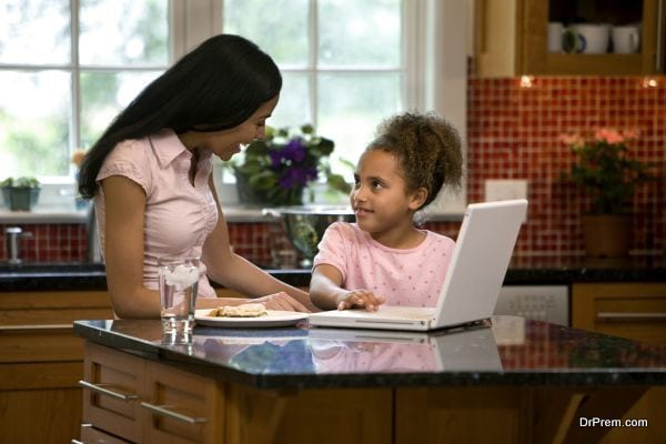 Mother and daughter in kitchen with laptop
