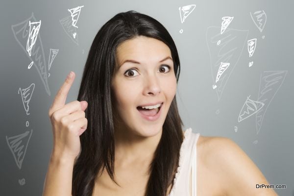 Attractive young woman signaling with her index finger that she has found a solution to a certain problem, on a gray studio background