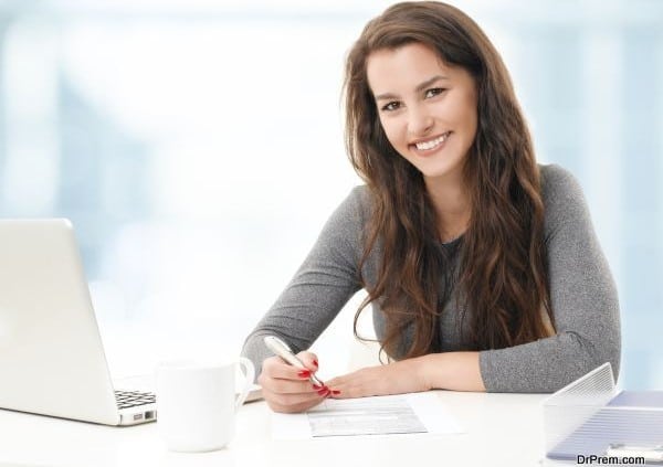 Portrait of young businesswoman fill the form while sitting at office.