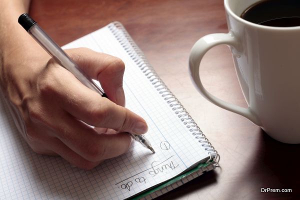 Womans hand with pen, notebook and coffee