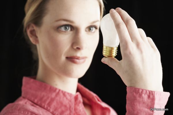 Focused woman looking at lightbulb