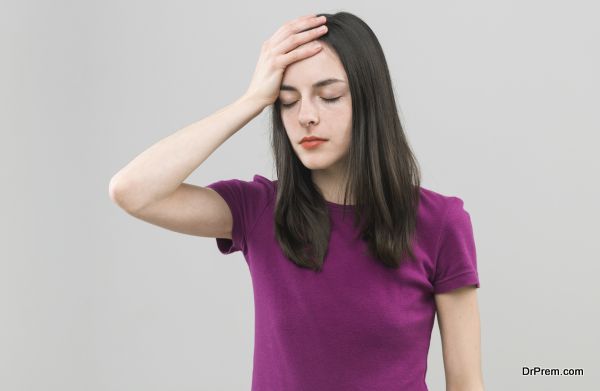 portrait of young caucasian woman suffering from headache