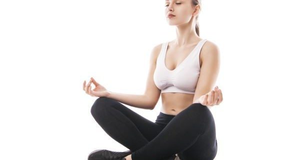Young woman sitting in lotus position isolated