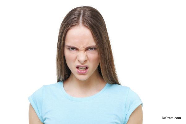Aggressive face of a young girl isolated on white background.