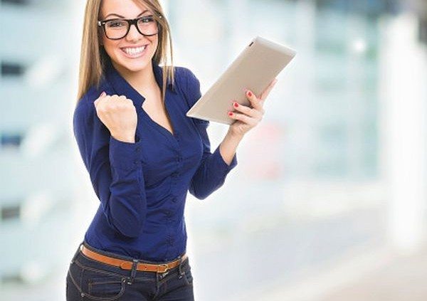 Excited happy young woman wearing glasses with tablet computer