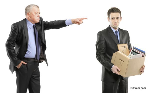 Angry boss firing a man with box of personal items