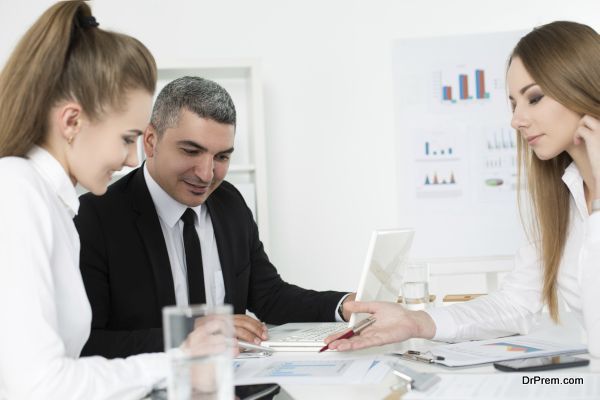 Adult businessman consulting his young female colleagues