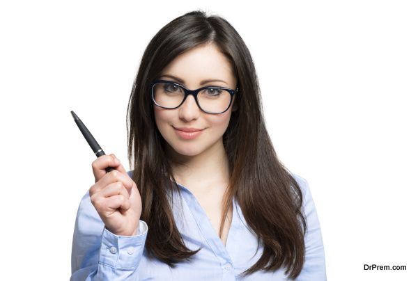 Portrait of a young smiling woman holding a pen