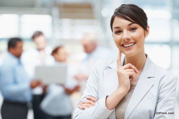 Smiling cute business woman with colleagues at the back